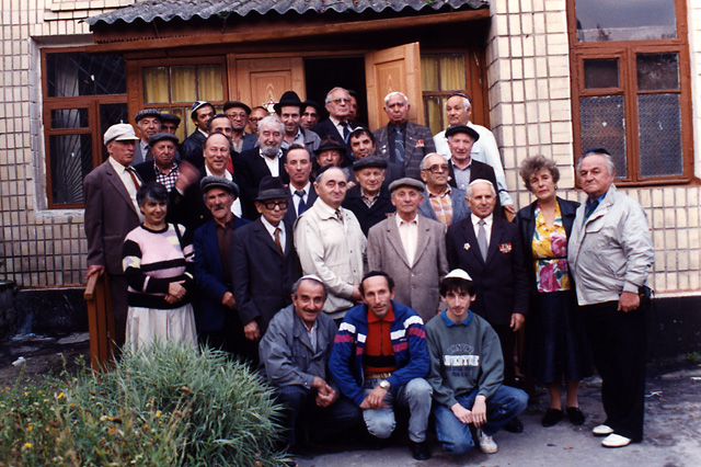 Paul Gass and Baruch Korff posing for a photo with some of the members of the Jewish community of Novograd Volynsk